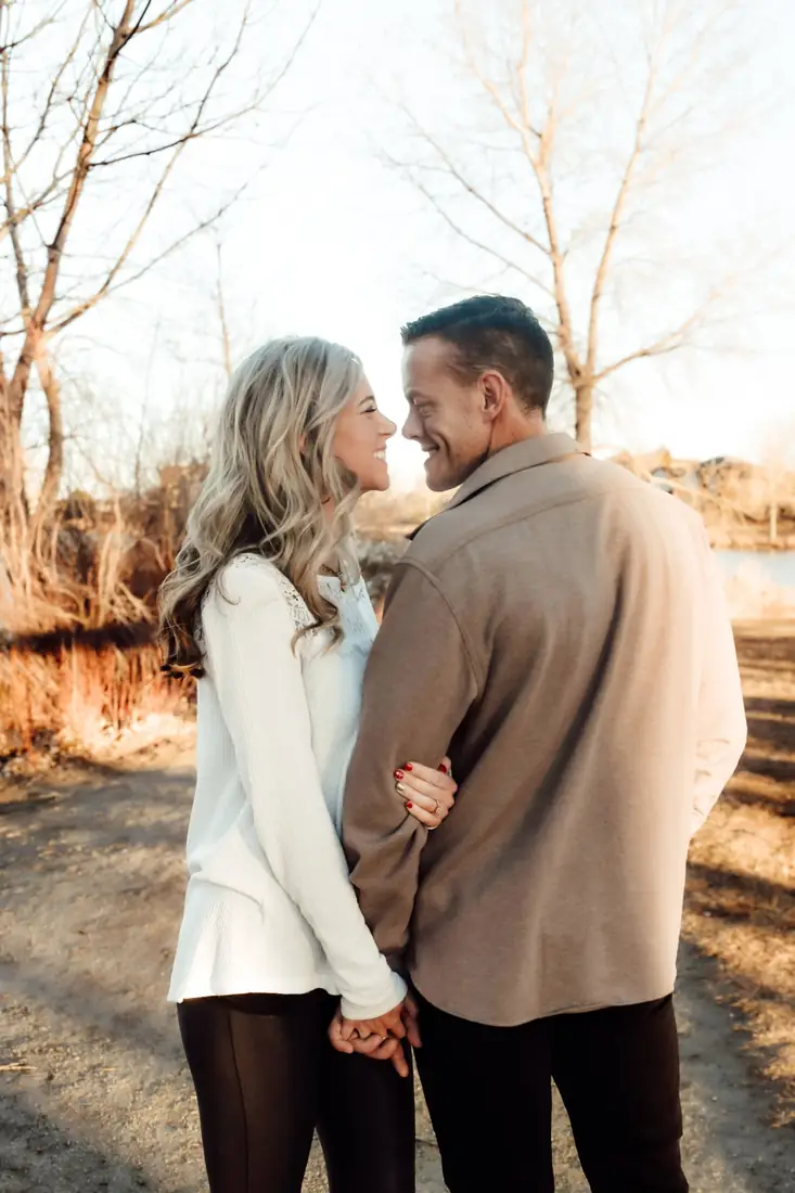 Engaged couple smiling at each other in golden light
